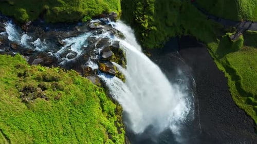 Vista desde arriba de las cataratas de Seljalandsfoss en Islandia con una poderosa cascada de agua desde un empinado acantilado. Orbe aéreo