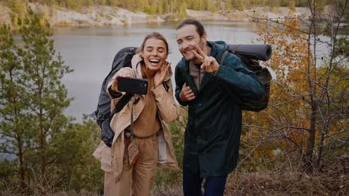 Woman and Man Taking Selfie While Hiking in Autumn Forest