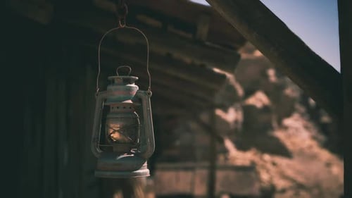 Vintage Kerosene Lamp Swaying in a Rustic Desert Landscape