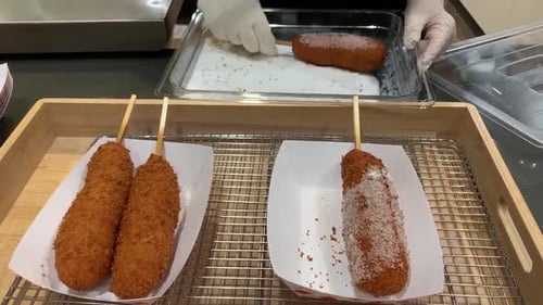 Famous Korean cheese hot dogs deep fried on a stick and lightly coated in white sugar.