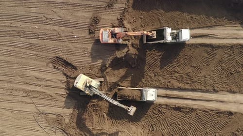 Bagger, die Anhänger-LKWs mit einer Ladung Erde beladen