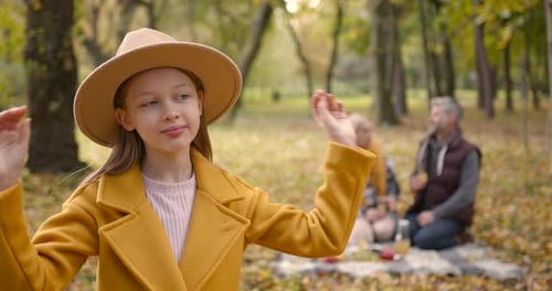 Girl in Hat and Coat in Autumn Park