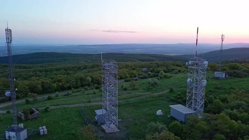 View of the Hills Covered with Vegetation with Cell Towers Against the Backdrop of Fields and a