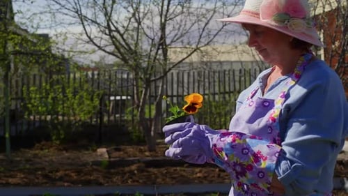 Woman Holds Flower in Sunny Garden