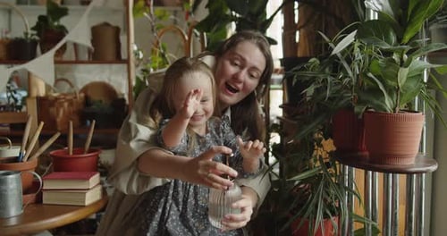 Loving Mother and Child Watering House Plants Together