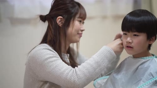 Woman Giving a Haircut to a Young Boy