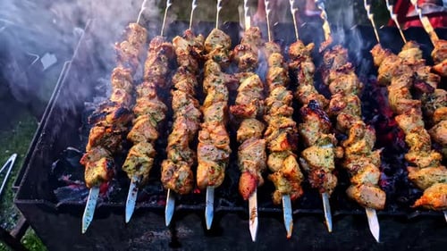Gegrillte Hähnchenspieße über heißen Kohlen, während des Grillens Rauch aufsteigt