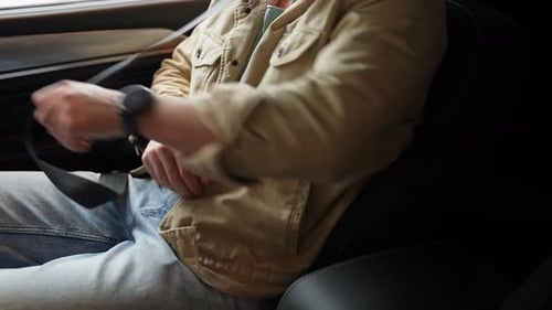 Closeup Side View of Unrecognizable Man Sitting on Front Passenger Seat Fastening Belt Harness