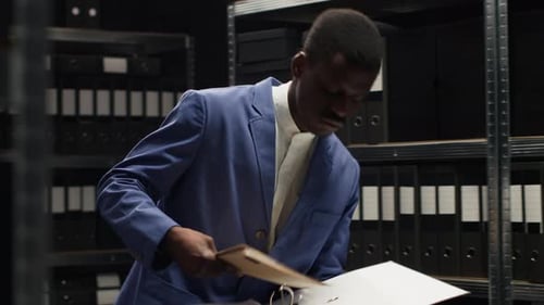 Man and Woman Review Documents in Office Filing Room