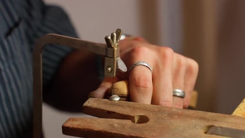 Artisan crafts wooden object with precision tools in a workshop setting during the day