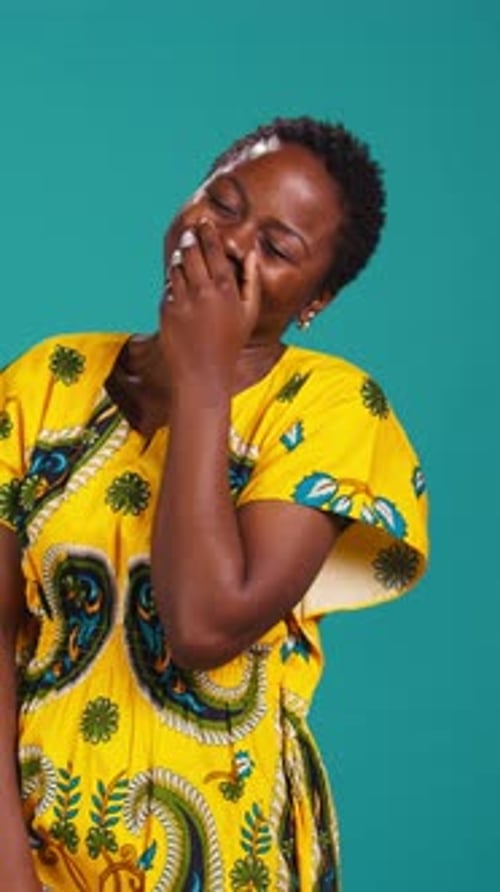 Vertical Video Cute Female Model Giggling Against Blue Background in Studio