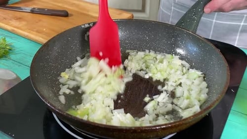 Frying Onions in Skillet Using Spatula for Cooking