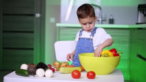 Boy Examines Vegetables in Kitchen