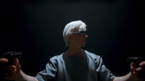 Man holding VR controllers in the dark