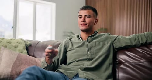Young Man Relaxing on Couch and Using Remote