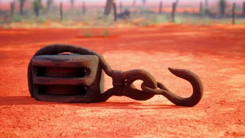 A Rusty Metal Hook on a Vibrant Red Dirt Road