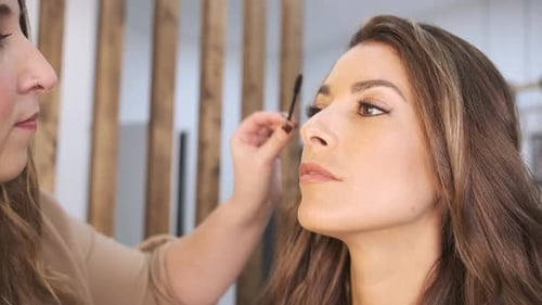 Woman Getting Eyebrows Brushed in Workplace Setting