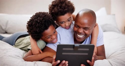 Father and Children Enjoying Tablet on Bed