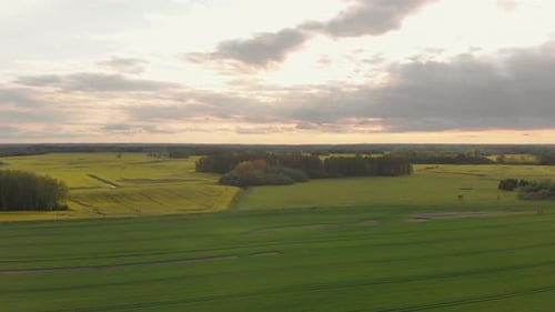 Gloomy skies dawning the agricultural lands of Europe Courland Latvia aerial