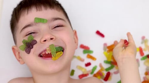 Boy Covered with Gummy Candies Lying Down