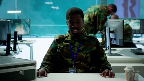 Army Personnel in a High Tech Command Center Attends a Videocall Meeting