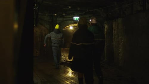 Team of Workers in Hard Hats are Walking in Mining Tunnel