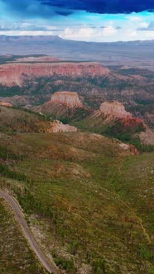Azure cloudy skies over the mountainous landscape of Utah canyons.