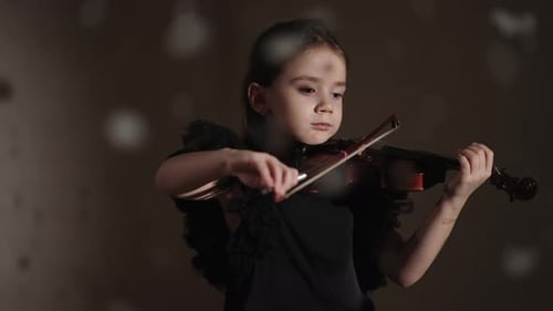 Talented Little Violinist Playing Fabulous Melody In Studio With Snow Flying Up Portrait