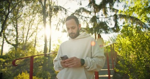 Uma garota morena feliz com um capuz amarelo corre até seu namorado moreno com barba por fazer e fecha