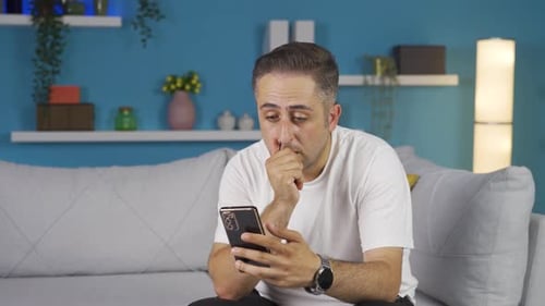 Man Uses Phone and Expresses Negative Emotions Indoors