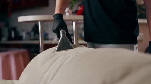 Man Cleaning Couch with Upholstery Extraction Tool