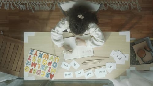 Child Learning to Read and Write at Desk