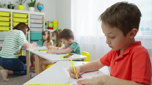 Children Drawing with Teacher in Bright Classroom