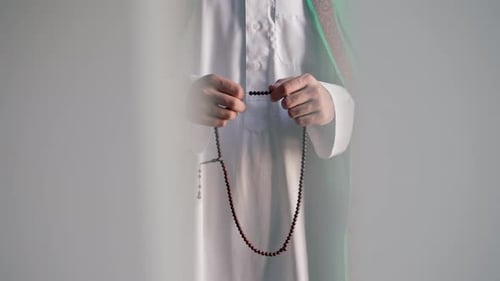 Man Holds Prayer Beads in Traditional Setting