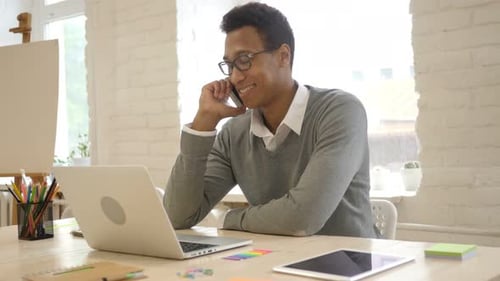 Professional Man Talking on Cell Phone at Desk