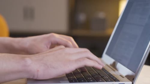 Close-up of hands typing on the keyboard.