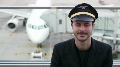 Smiling Pilot Portrait in Airport with Commercial Airplane