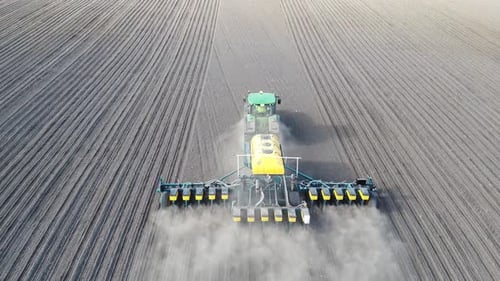 Tractor with yellow seeder working on the field in Ukraine OA Lexa