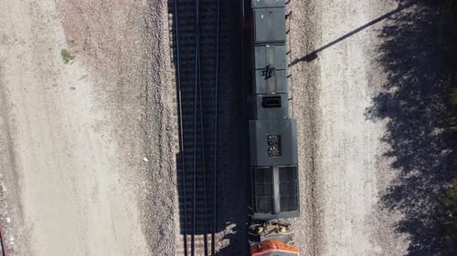 Luftaufnahmen von oben nach unten von einer Drohne, die direkt auf einen Zug schaut, der sich von oben bewegt