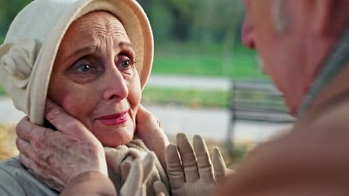 Elderly Female in Elegant Outfit Looking at Husband with Sadness While Saying Goodbye to Him in Park