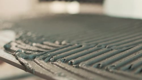 Spreading adhesive on tile for home renovation