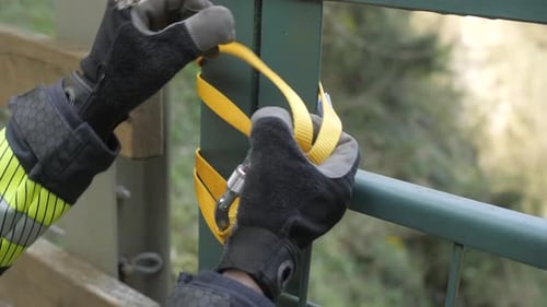 closeup of firefighter hands tightening rope with carabiner before descending