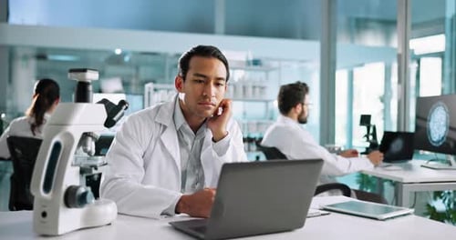 Man Working on Laptop in Bright Lab