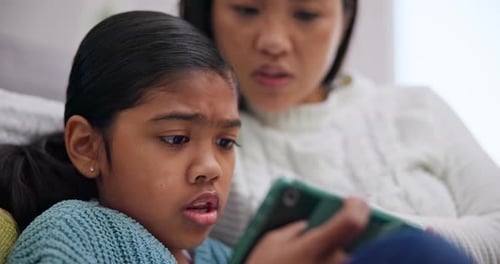 Girl and Adult Looking at Tablet Device Indoors