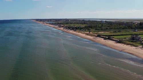 Beautiful flight in summer over the beach. People are resting near the sea. Houses for tourists.