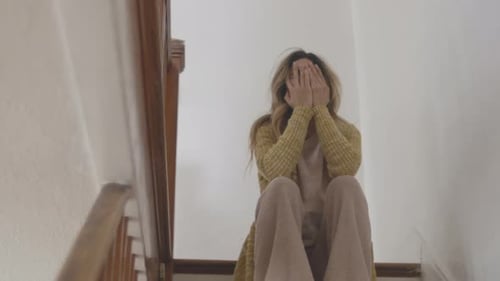 Distressed Woman Sitting on Stairs Crying