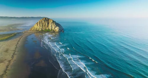 Aerial Drone Flight Over Morro Rock Coastline On Sunny California Day