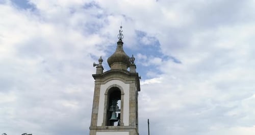 Close Up Details Of A Bell Tower Of A Church Against Blue Sky With White Clouds low angle orbiting