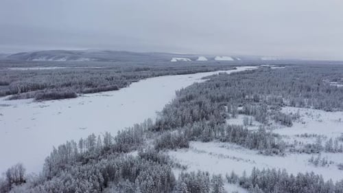 Aerial view of frozen river and snowy trees, Russia.