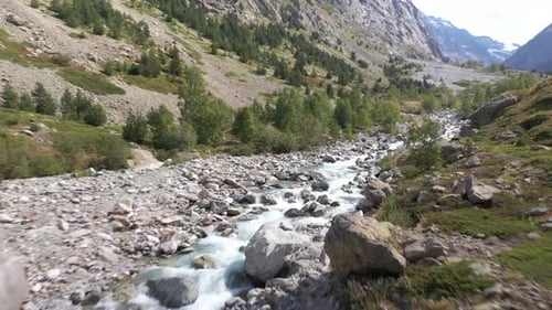 Atemberaubende Luftüberführung von mächtigen Stromschnellen, die durch eine Berglandschaft fließen